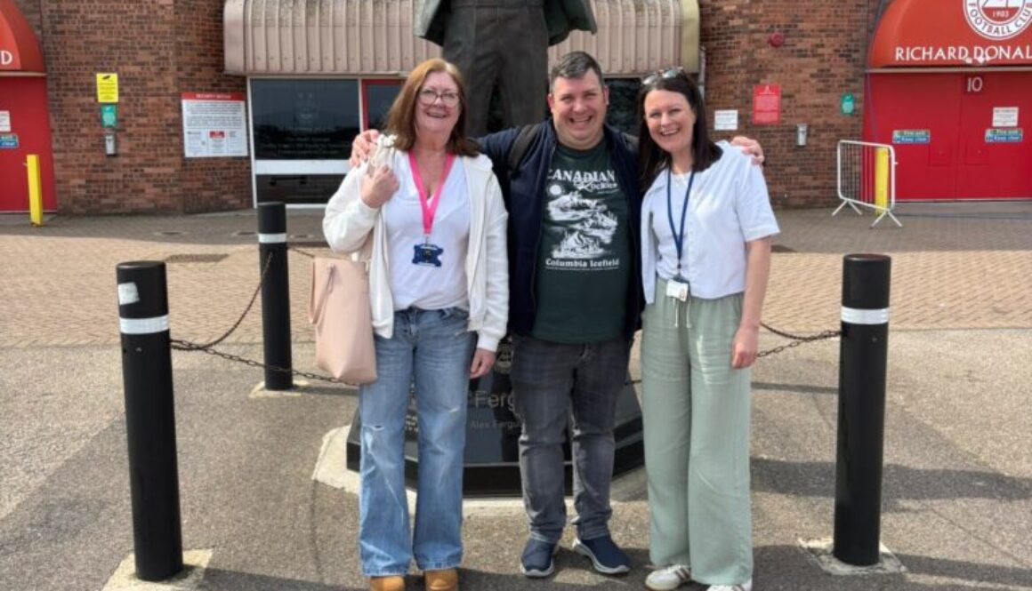 3 NETRALT members in front of Sir Alex Ferguson statue outside Pittodrie Stadium